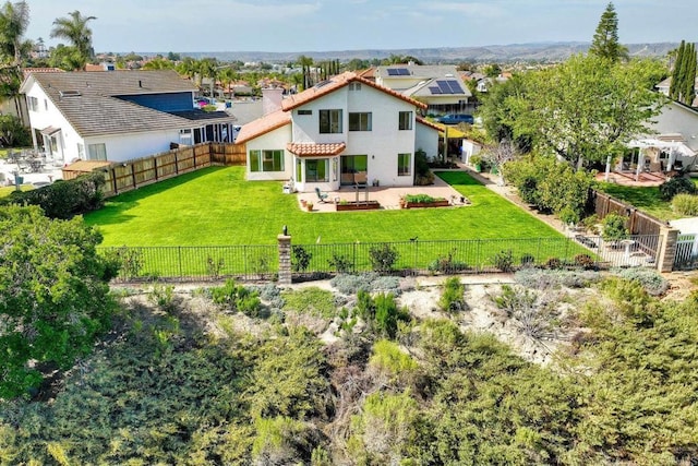 rear view of house with a patio area, a fenced backyard, a lawn, and stucco siding