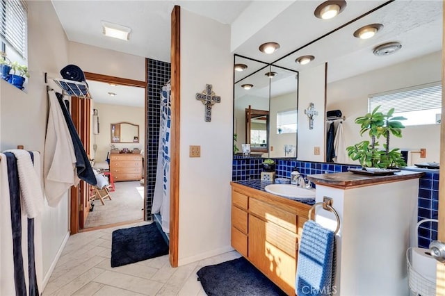 bathroom featuring a healthy amount of sunlight, tasteful backsplash, and vanity