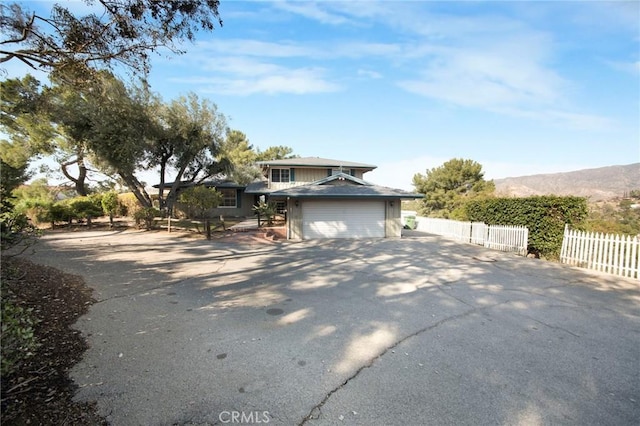 view of front facade with fence and driveway