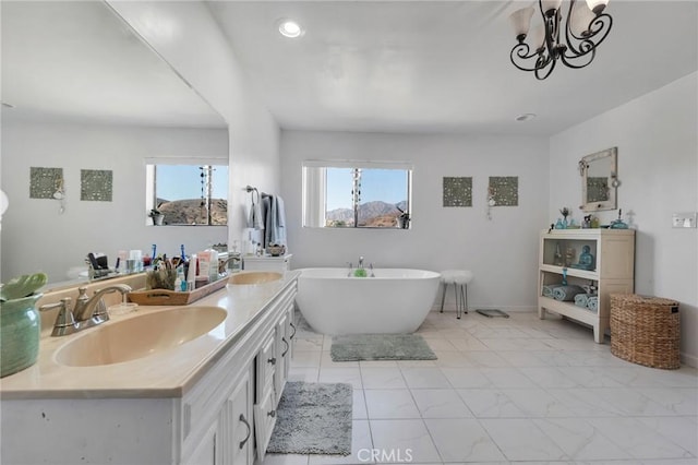 bathroom featuring marble finish floor, double vanity, a soaking tub, and a sink