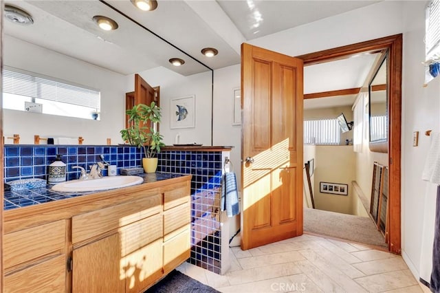 bathroom with tasteful backsplash and vanity