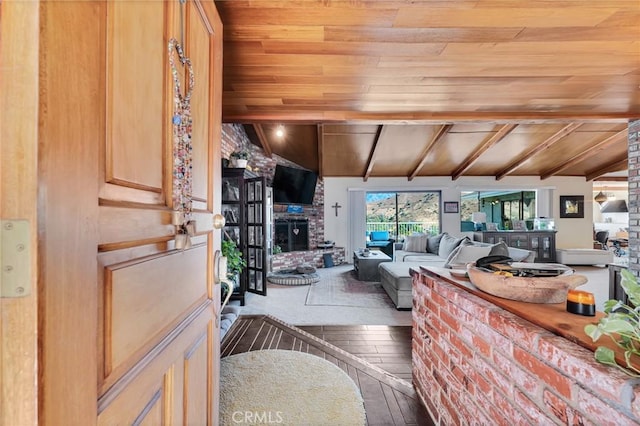 living area featuring wood ceiling, a brick fireplace, wood-type flooring, and beam ceiling