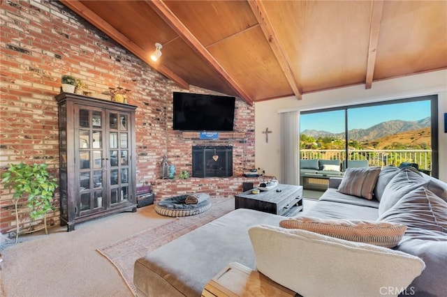 carpeted living area with lofted ceiling with beams, a brick fireplace, wood ceiling, and brick wall