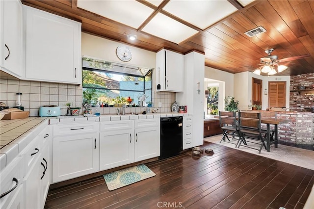 kitchen featuring a healthy amount of sunlight, black dishwasher, tile counters, and tasteful backsplash