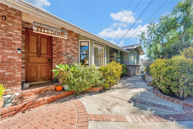 doorway to property featuring brick siding