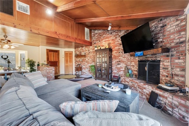 living room with visible vents, a ceiling fan, wooden ceiling, a fireplace, and beam ceiling