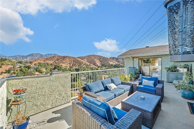 view of patio / terrace with a mountain view, a balcony, and an outdoor living space