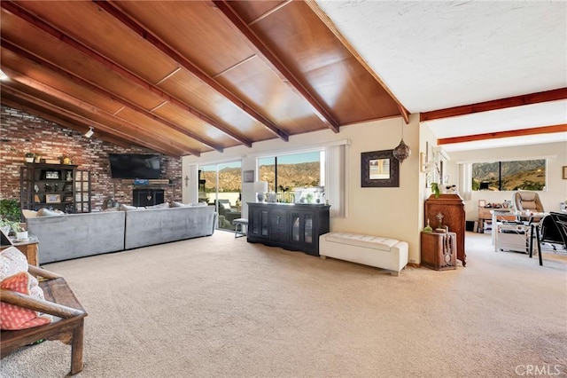 carpeted living area featuring vaulted ceiling with beams and brick wall