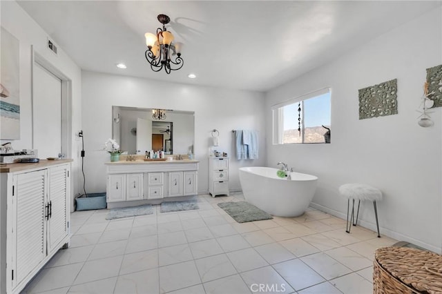 full bathroom with recessed lighting, a notable chandelier, visible vents, vanity, and a freestanding bath