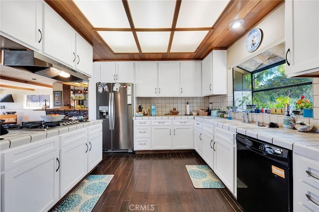 kitchen with tasteful backsplash, white cabinets, tile countertops, dark wood-style flooring, and stainless steel appliances