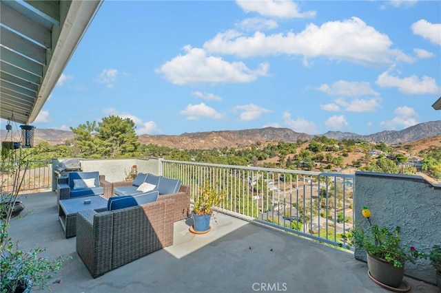 balcony featuring a mountain view and an outdoor living space