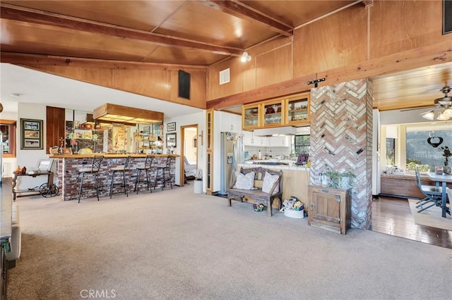 living area featuring visible vents, wooden ceiling, beamed ceiling, carpet flooring, and high vaulted ceiling