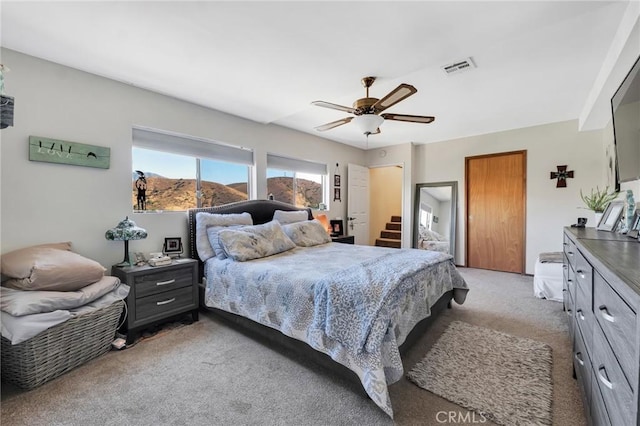 bedroom with a ceiling fan, light colored carpet, and visible vents