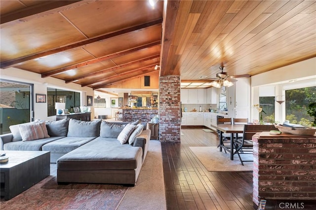 interior space featuring a ceiling fan, wood ceiling, dark wood finished floors, and lofted ceiling with beams