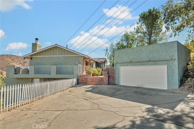 view of front facade with fence and stucco siding