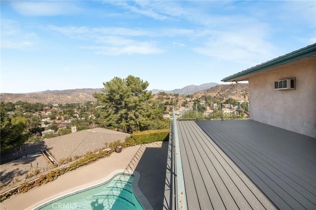 deck with an outdoor pool and a mountain view