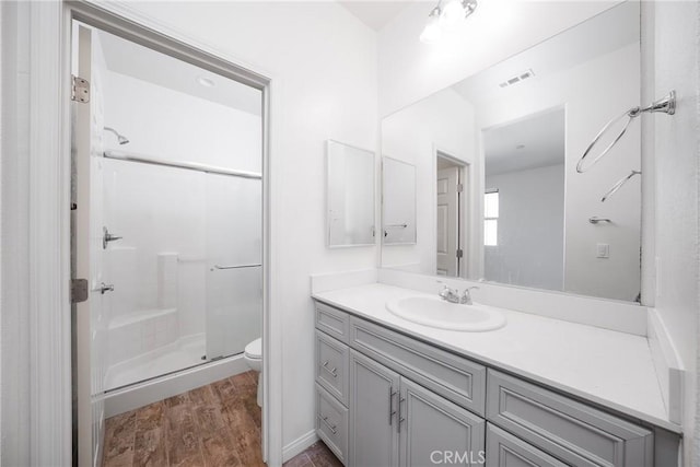 711 Banyan Way, Pomona, CA 91767 - bathroom with toilet, wood finished floors, visible vents, vanity, and a stall shower