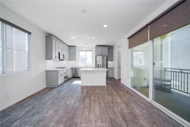 711 Banyan Way, Pomona, CA 91767 - kitchen featuring dark wood-style floors, a center island, stainless steel appliances, light countertops, and gray cabinetry