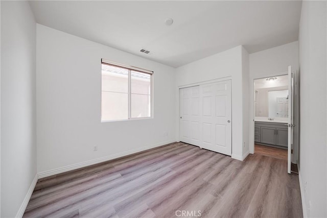 711 Banyan Way, Pomona, CA 91767 - unfurnished bedroom featuring light wood-style floors, a closet, a sink, and baseboards