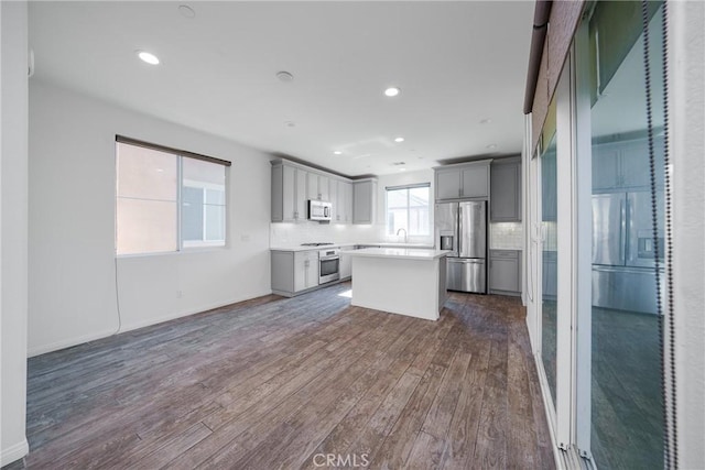 711 Banyan Way, Pomona, CA 91767 - kitchen featuring a kitchen island, light countertops, appliances with stainless steel finishes, gray cabinets, and dark wood finished floors