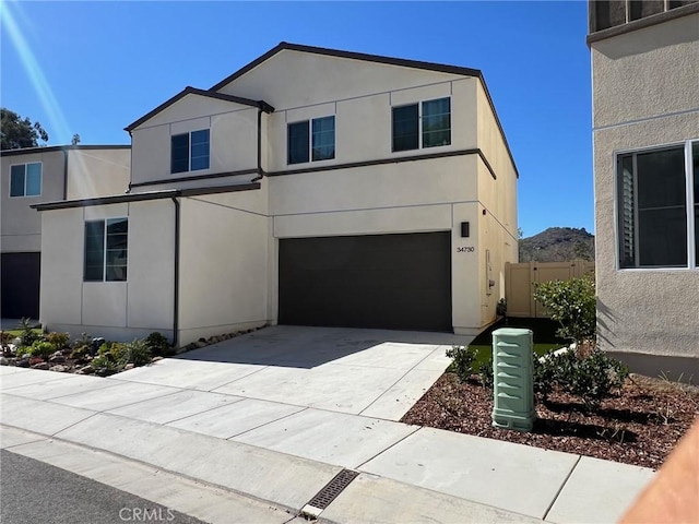 view of front facade featuring driveway, an attached garage, and stucco siding