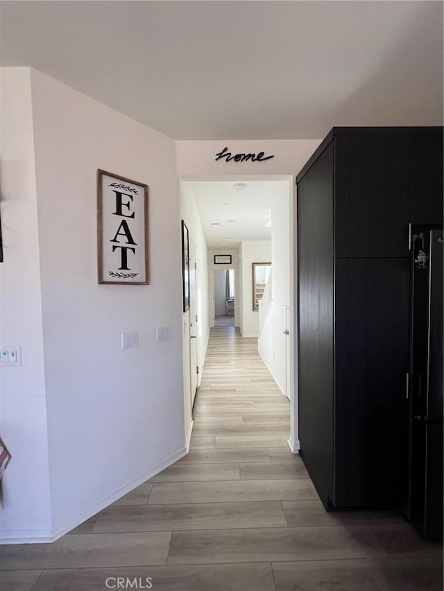 hallway with light wood-style floors and baseboards