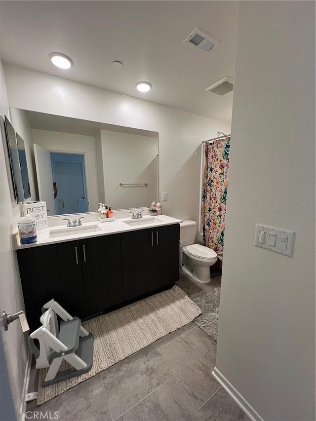 full bath featuring visible vents, a sink, toilet, and double vanity