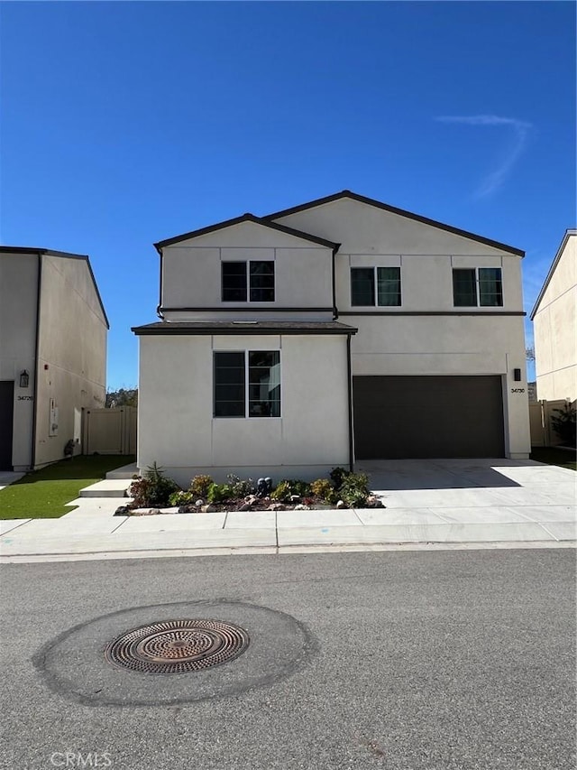 view of front facade with driveway, a garage, and stucco siding