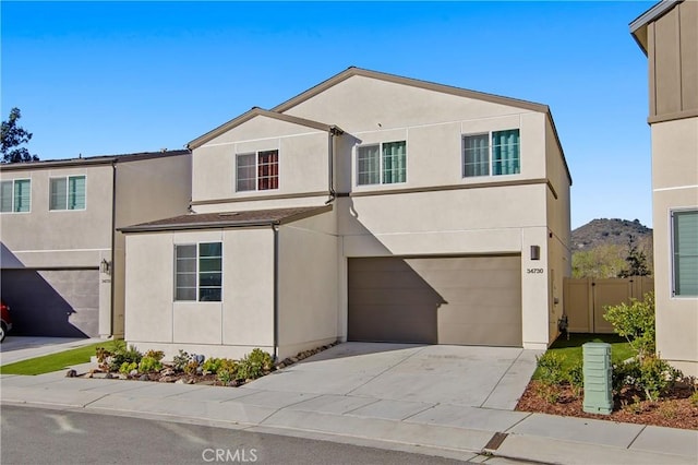 traditional-style house featuring an attached garage, driveway, and stucco siding