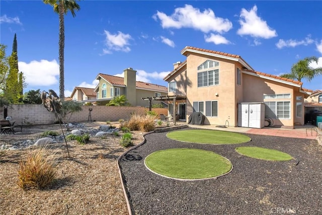 back of house with a fenced backyard, a patio, and stucco siding