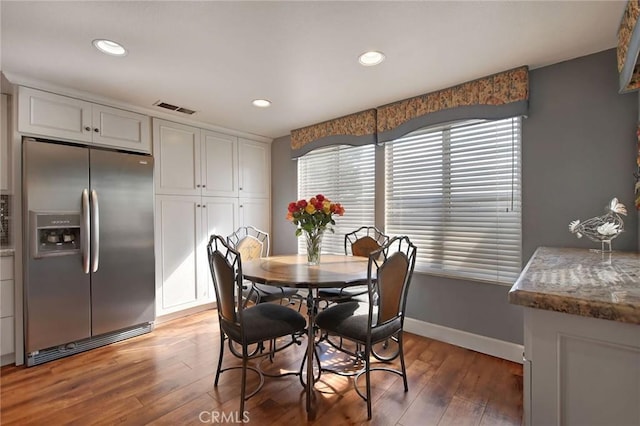 dining room featuring baseboards, visible vents, dark wood-type flooring, and recessed lighting