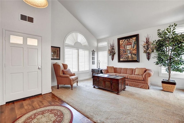 living room with high vaulted ceiling, carpet floors, visible vents, and baseboards