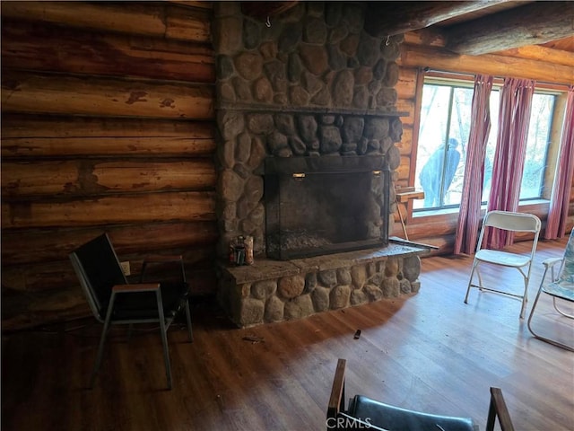 living area with rustic walls, wood finished floors, and a stone fireplace