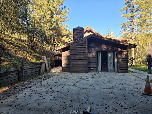 back of property featuring a patio, a chimney, and fence