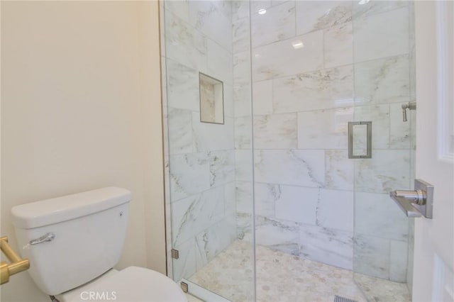 bathroom featuring toilet and a stall shower