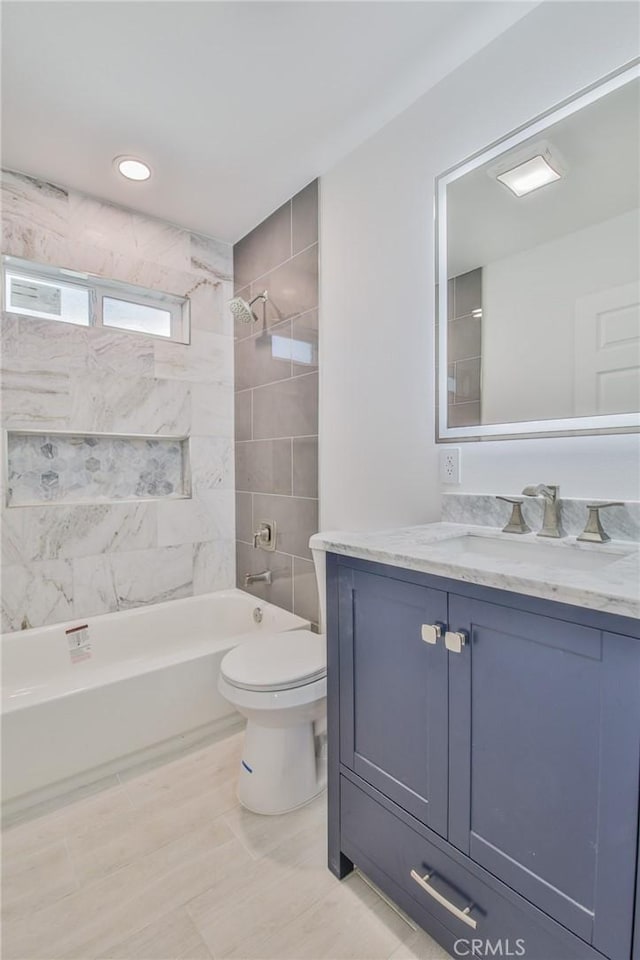 bathroom with washtub / shower combination, vanity, and toilet