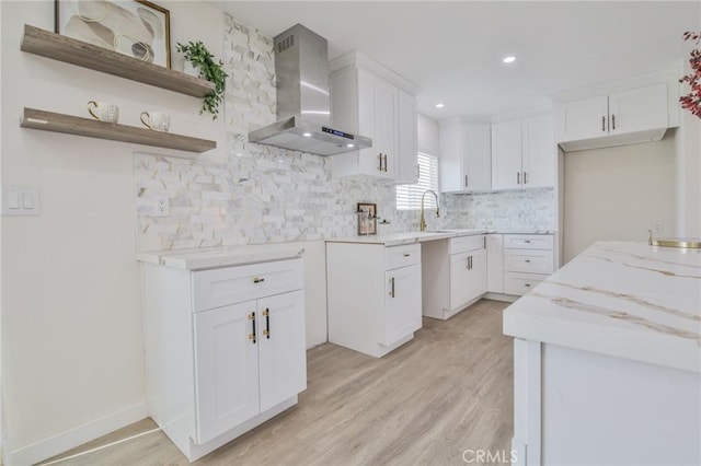 kitchen featuring white cabinets, wall chimney exhaust hood, and open shelves