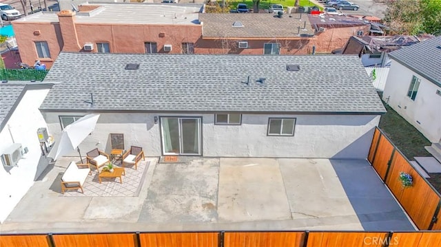 rear view of property with a patio area, fence, and stucco siding