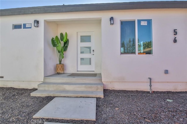 doorway to property featuring stucco siding