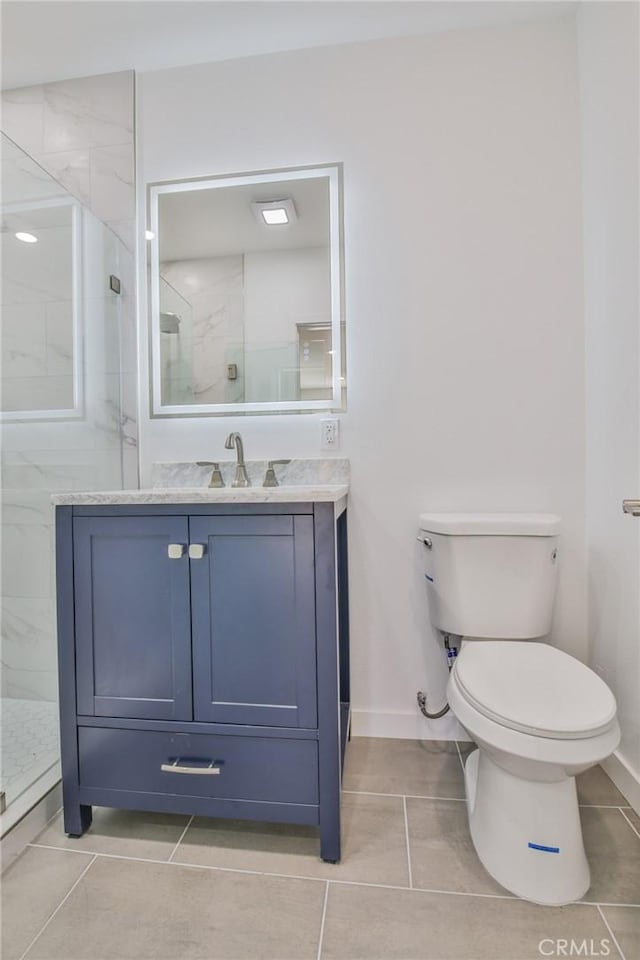 bathroom with toilet, vanity, tile patterned flooring, baseboards, and walk in shower