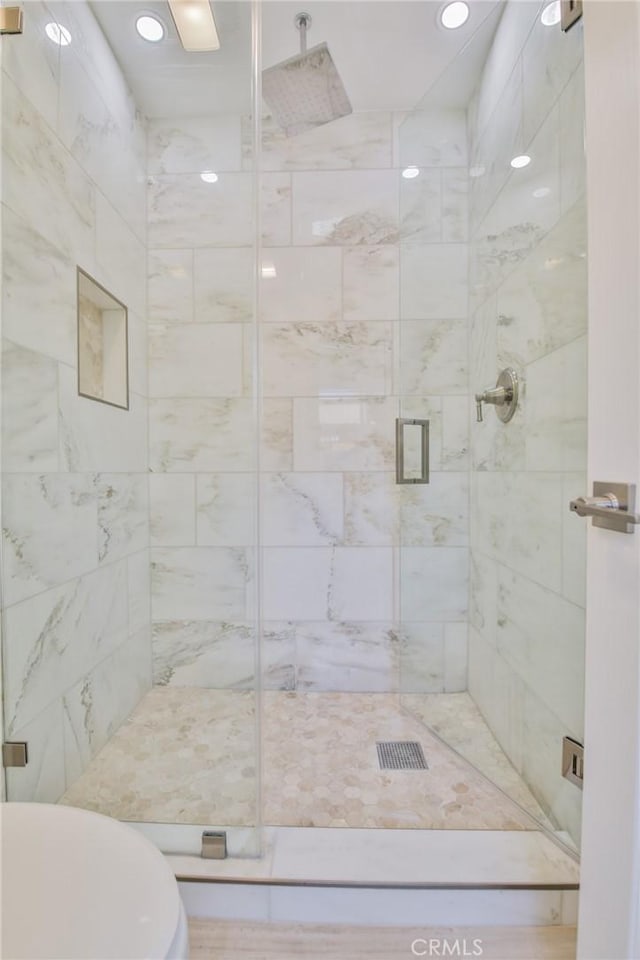 bathroom featuring a stall shower and toilet