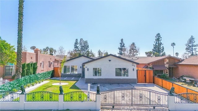 view of front of home with a fenced front yard, a residential view, a gate, and stucco siding