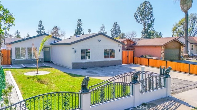 view of front facade featuring a fenced front yard, a gate, and stucco siding