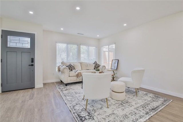 living room featuring light wood-style floors, baseboards, and recessed lighting