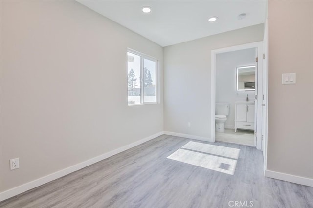 unfurnished bedroom with light wood-type flooring, baseboards, and recessed lighting