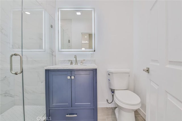 bathroom with a marble finish shower, baseboards, vanity, and toilet