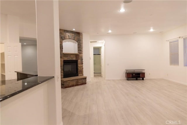 1594 Margit St, Redlands, CA 92374 - unfurnished living room featuring baseboards, recessed lighting, a stone fireplace, and light wood-style flooring