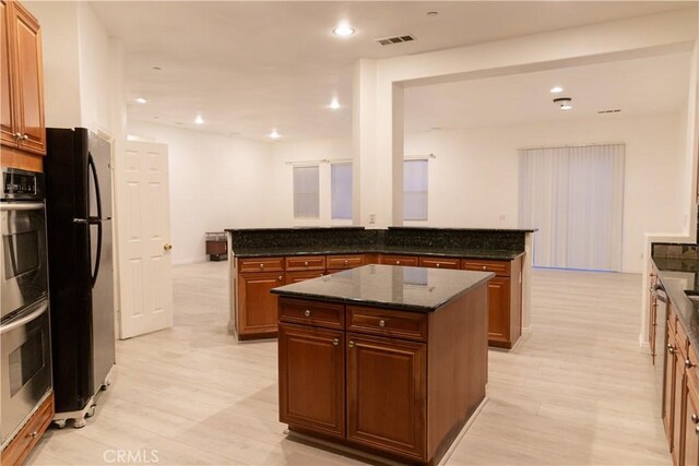 1594 Margit St, Redlands, CA 92374 - kitchen with visible vents, double oven, a peninsula, and freestanding refrigerator
