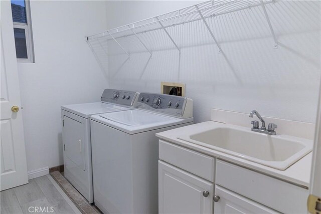 1594 Margit St, Redlands, CA 92374 - laundry room featuring separate washer and dryer, a sink, cabinet space, and light wood-style floors