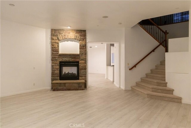 1594 Margit St, Redlands, CA 92374 - unfurnished living room featuring a stone fireplace, stairway, wood finished floors, and baseboards